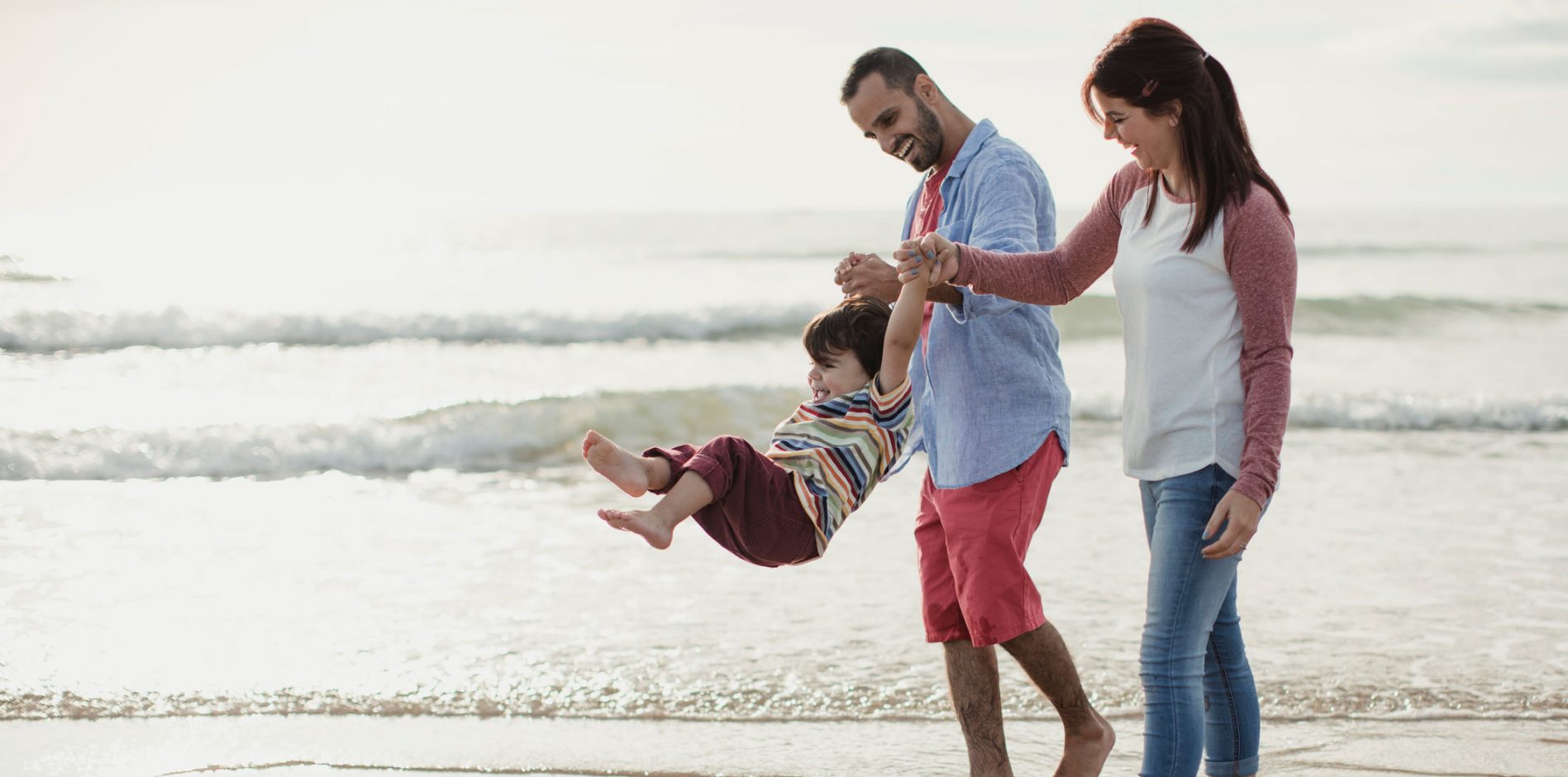 Family of 3 on beach whilst on holiday