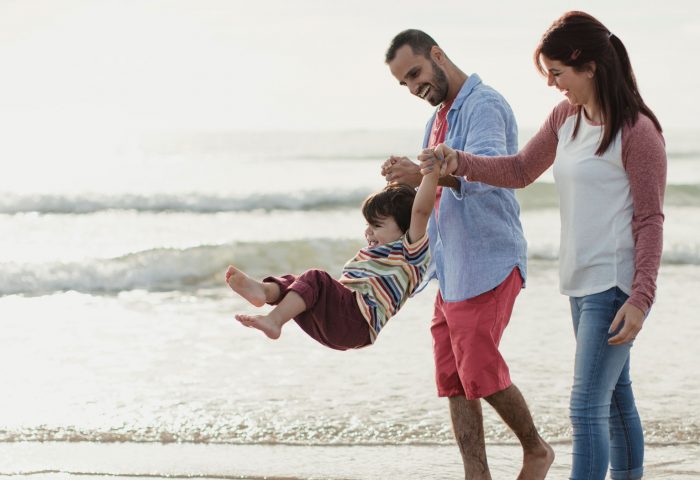 Family of 3 on beach whilst on holiday