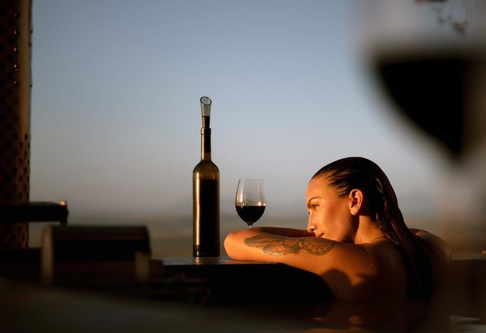 Woman looking at sunset in North Devon from hot tub in Holiday Cottage