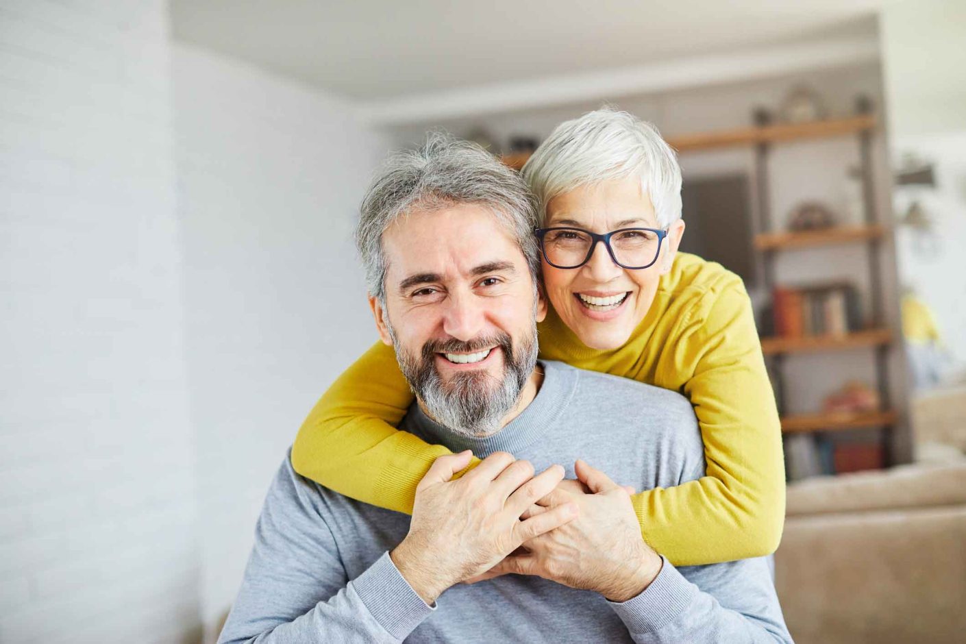 Happy middle aged couple with grey hair in holiday home