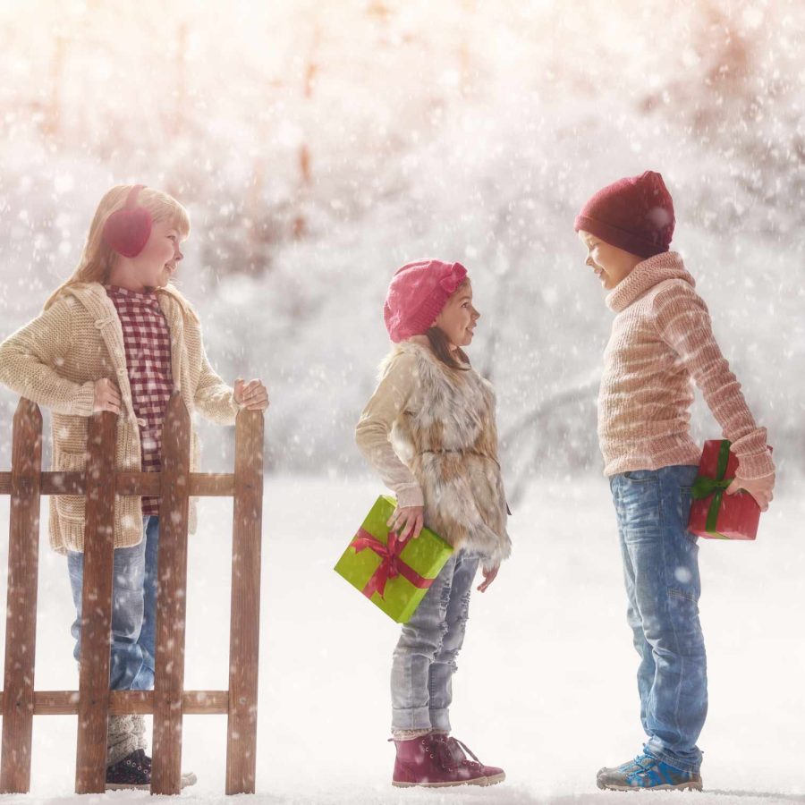 Children playing in the snow at Christmas