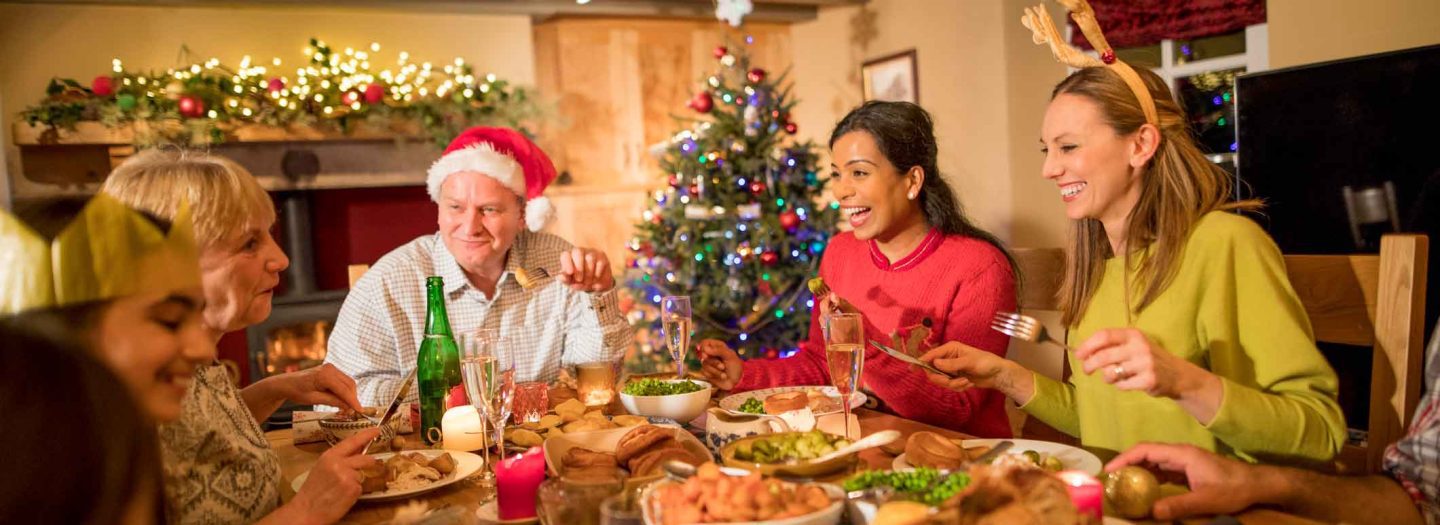 Family having christmas dinner at large table in holiday cottage