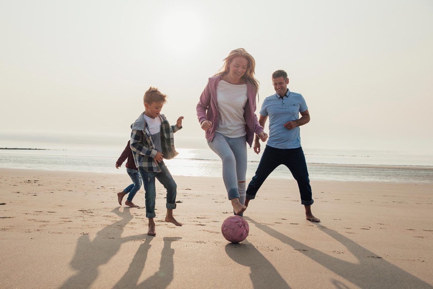 Family playing football on the beach in Woolacombe