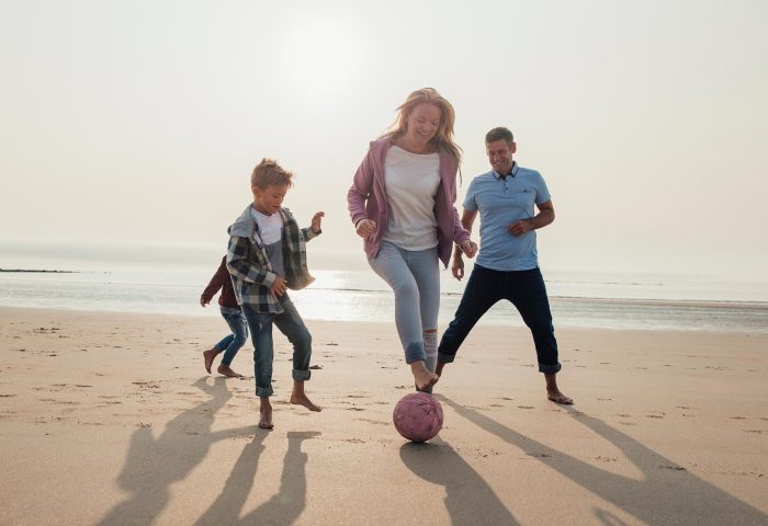 Family playing football on the beach in Woolacombe