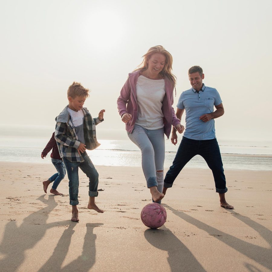 Family playing football on the beach in Woolacombe