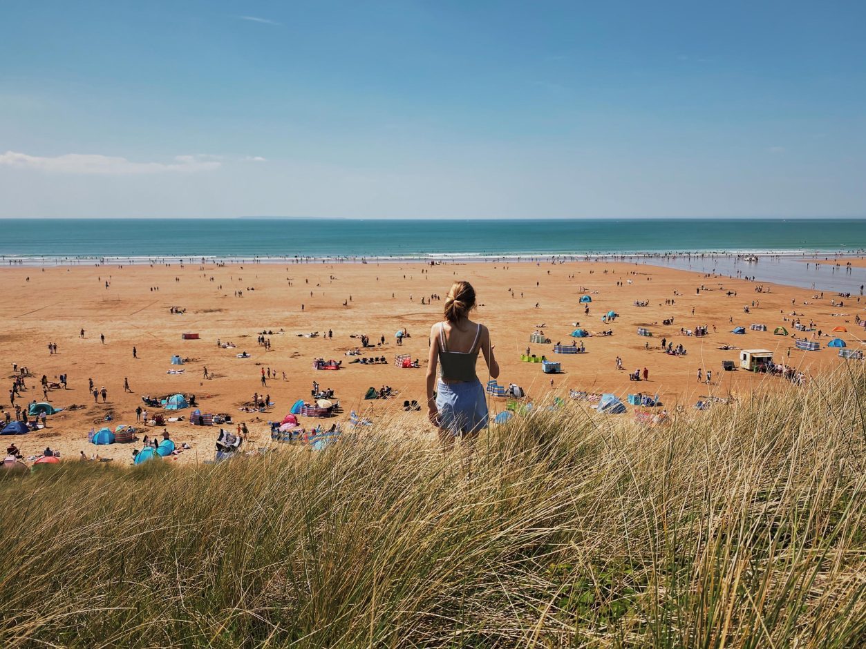 A Girl looking out onto Woolacombe Beach on sunny day