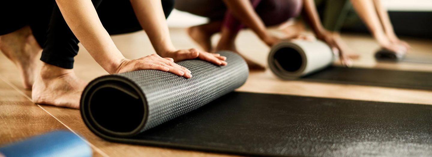 Women rolling mats at a pilates class