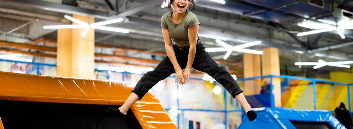 Girl jumping on colourful trampoline at trampoline park