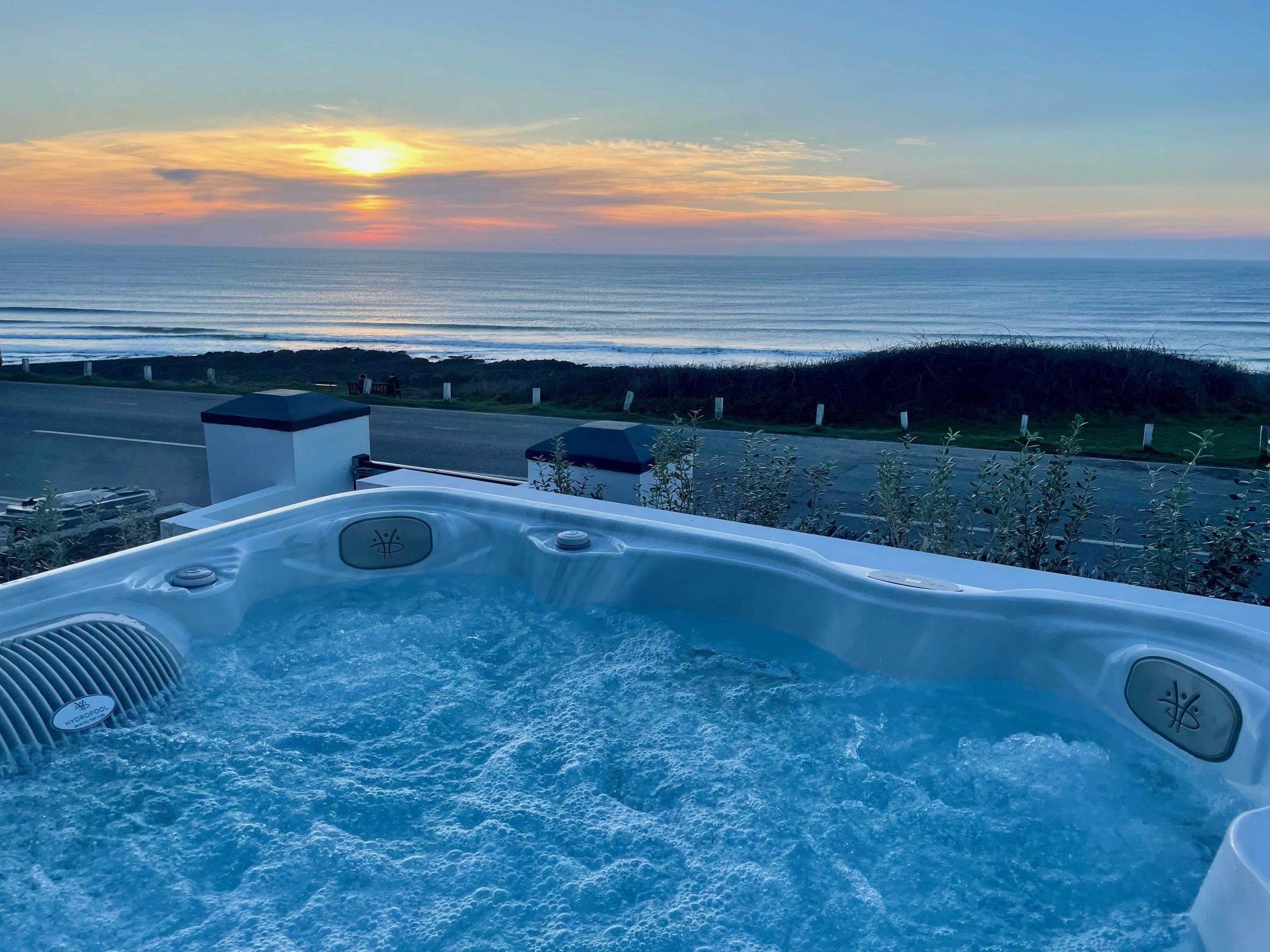 Hot tub with sea view in the background and sunset